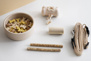 Eco-friendly pet products including toys, food bowls, and natural accessories arranged on a wooden table