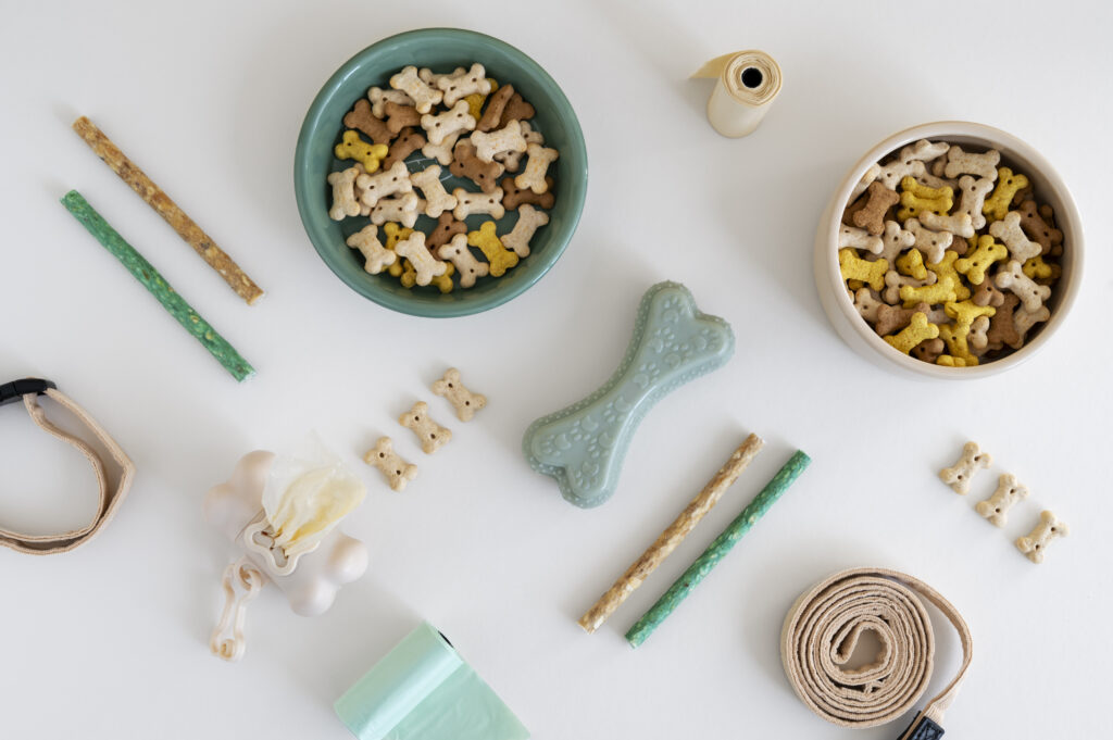 Eco-friendly pet products including toys, food bowls, and natural accessories arranged on a wooden table